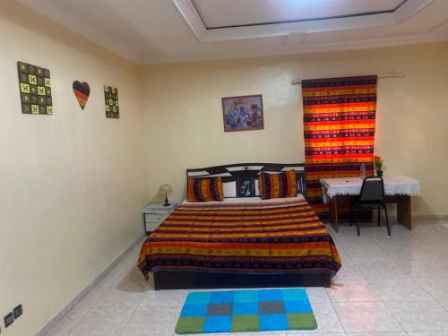 a bedroom with a bed and a table in it at CREPE GAME in Nouakchott