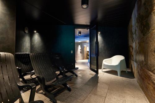 a hallway with chairs and a white chair in a room at 3s HOTEL ATSUGI in Atsugi