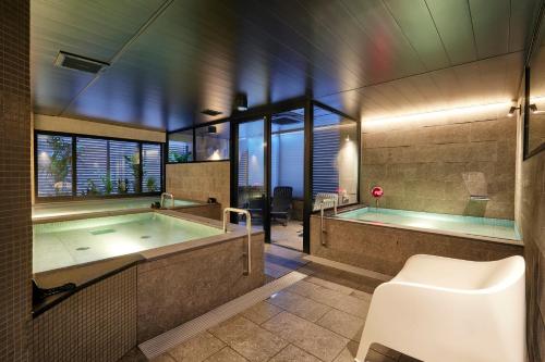 a bathroom with a bath tub and a bath tub at 3s HOTEL ATSUGI in Atsugi