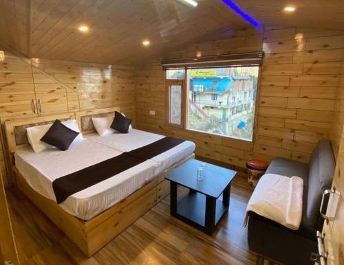 Eden Hotel and Resort في شيملا: غرفة نوم بسرير في كابينة خشبية