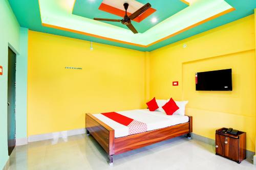a bedroom with a bed with yellow walls and a ceiling at Dreams Inn in Kolkata