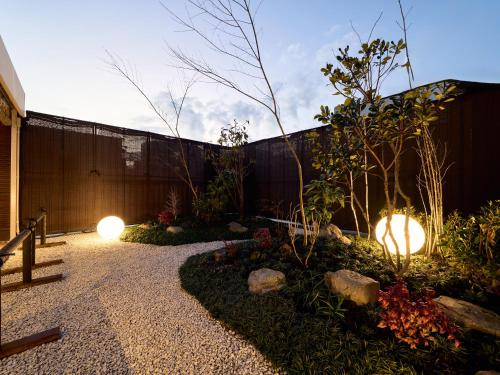a garden with lights on the side of a fence at KONJAKUSO Osaka Bentencho "OKUJO-TEIEN" Rooftop Garden in Osaka