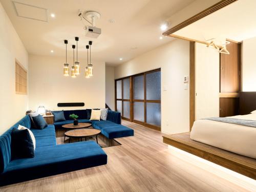 a bedroom with a blue couch and a bed at KONJAKUSO Osaka Bentencho "OKUJO-TEIEN" Rooftop Garden in Osaka