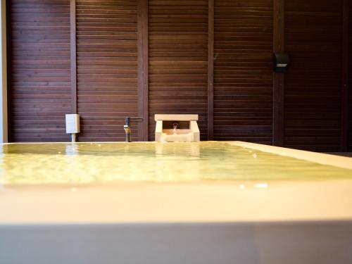 a swimming pool with a chair in a room at KONJAKUSO Osaka Bentencho "OKUJO-TEIEN" Rooftop Garden in Osaka