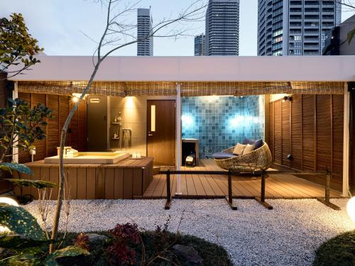 a deck with a couch and a tub in a city at KONJAKUSO Osaka Bentencho "OKUJO-TEIEN" Rooftop Garden in Osaka