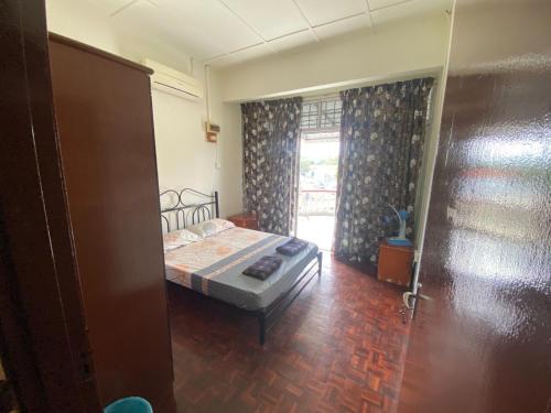 a bedroom with a bed and a window at JAST 9 HOMESTAY in Port Dickson