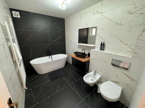 Private building - Apartment في بيستريتسا: حمام مع حوض وحوض استحمام ومرحاض