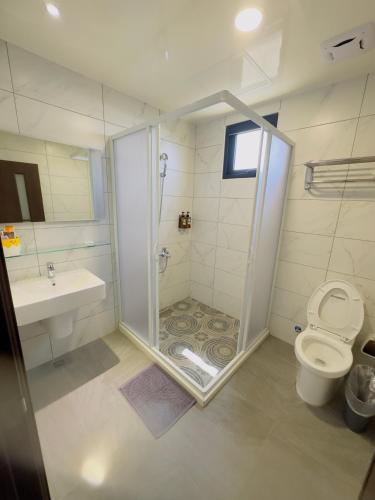 a bathroom with a shower and a toilet and a sink at Diving Duck B&B in Magong