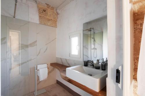 a white bathroom with a sink and a mirror at Masseria Misocampo - Happy Rentals in Calimera