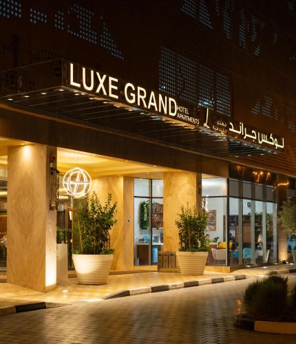 a building with a sign that reads live grand at Luxe Grand Hotel Apartments in Sharjah