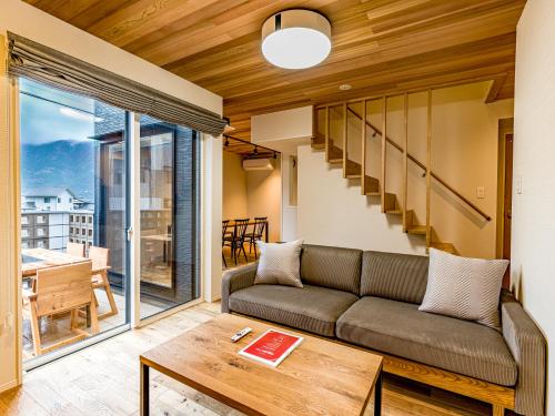 a living room with a couch and a table at Rakuten STAY HOUSE x WILL STYLE Yufuin Kawakami in Yufu