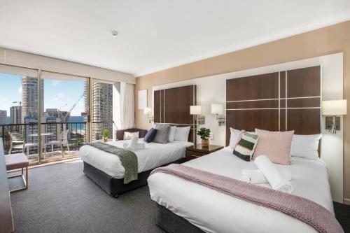a hotel room with two beds and a balcony at Comfy Surfers Paradise Studio with Ocean View in Gold Coast