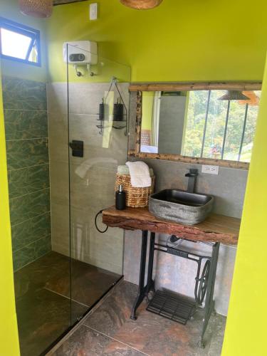 a bathroom with a glass shower and a sink at Glamping ríos voladores in Pereira
