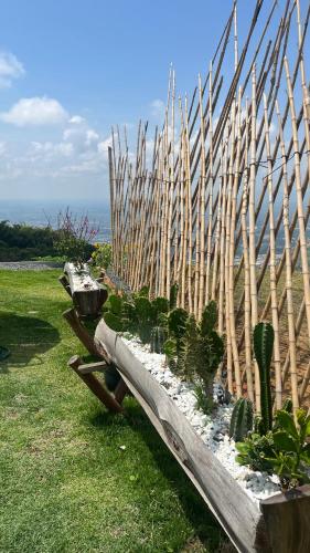a wooden bench with plants in it next to a fence at Glamping ríos voladores in Pereira