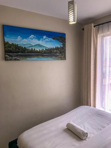 Schlafzimmer mit einem Bett mit Wandgemälde in der Unterkunft Harmony Condo in Nairobi