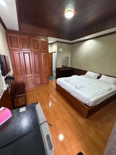 een grote slaapkamer met een bed en een bureau bij Mona House Phuket in Ban Na Bon