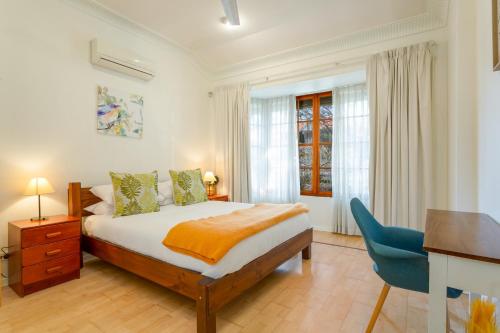 um quarto com uma cama, uma secretária e uma cadeira em Spacious 3-Bed Mid Century Home Near CBD em Sydney