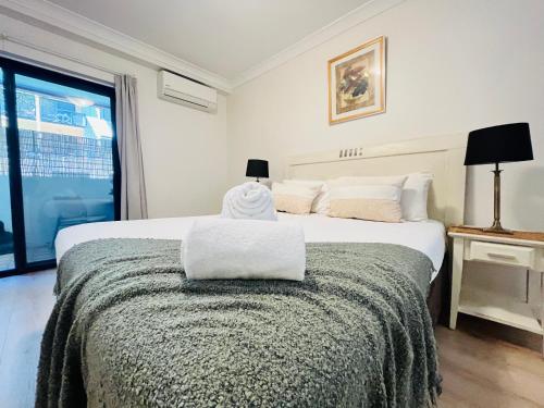 a bedroom with a large white bed with a window at 2 Paradise Pool Parking Huge 1br Cbd in Perth