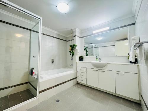 a bathroom with a tub and a sink and a shower at 2 Paradise Pool Parking Huge 1br Cbd in Perth
