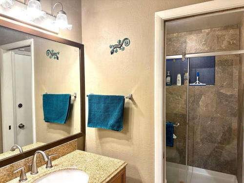 ein Badezimmer mit einem Waschbecken und einer Dusche mit blauen Handtüchern in der Unterkunft Casa Rio spacious 3 bd/ 3.5 bath near airport in Las Vegas