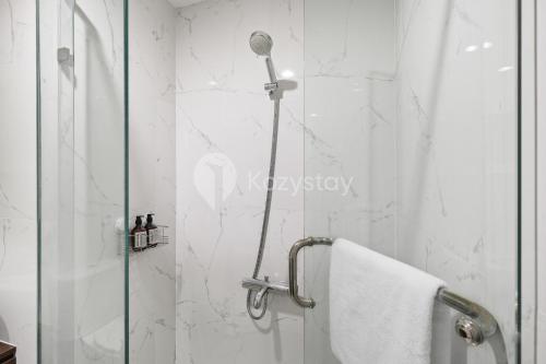 ducha con puerta de cristal junto a la ducha en Gratia by Kozystay - 1BR - City View - Kuningan en Yakarta