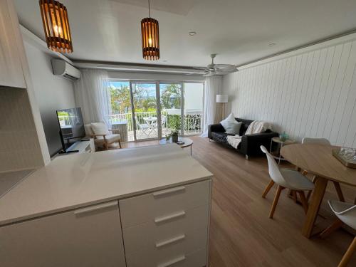 Pelican Cove Apartments في غولد كوست: مطبخ وغرفة معيشة مع أريكة وطاولة