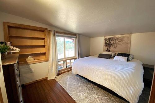 een slaapkamer met een wit bed en een raam bij Private Ranch Log Cabin Lakeside Escape in Shady Cove