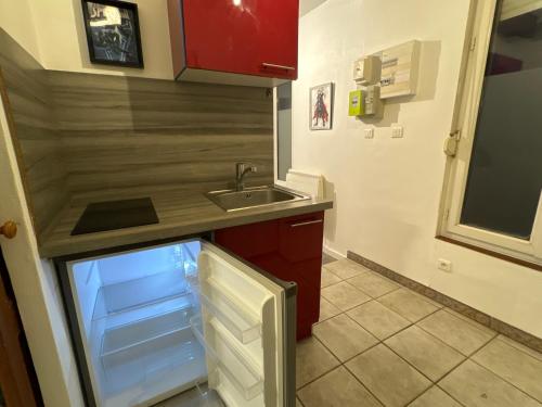 une cuisine vide avec évier et réfrigérateur vide dans l'établissement Avengers, à Besançon