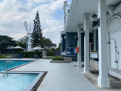 a swimming pool next to a building with a house at Indy 2 Bangna KM 7 Cozy Townhome near Ikea Mega Bangna 15m to Airport in Bang Kew Yai