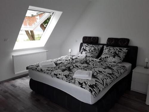 Cama en blanco y negro en habitación con ventana en Nice holiday apartment in Ostbevern en Ostbevern