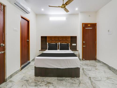 Super OYO Hotel Arjun Residency في Khammam: غرفة نوم بسرير ومروحة سقف