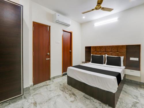 a bedroom with a large bed and a ceiling fan at Super OYO Hotel Arjun Residency in Khammam