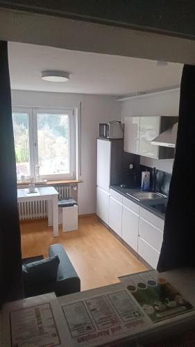 cocina con armarios blancos y ventana grande en Fridolin, en Eichenbühl