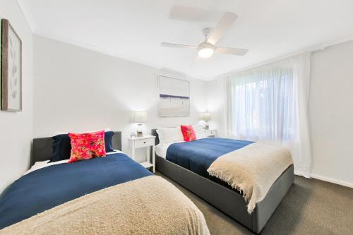 a bedroom with two beds and a ceiling fan at Henley Hideaway in Henley Beach South