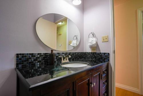 ein Bad mit einem Waschbecken und einem Spiegel in der Unterkunft Beautiful 5 BDRM Home, Fenced Yard, WiFi, Fireplace, Free Parking, Transit, Town Centre - Sleeps 12 in Edmonton