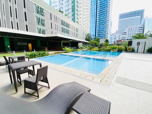 a pool with chairs and a table and a table and chairs at Cebu Avida Riala by P&J in Cebu City