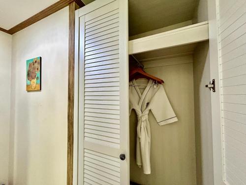 a closet with a white door and some clothes at Okpo business hotel in Geoje 