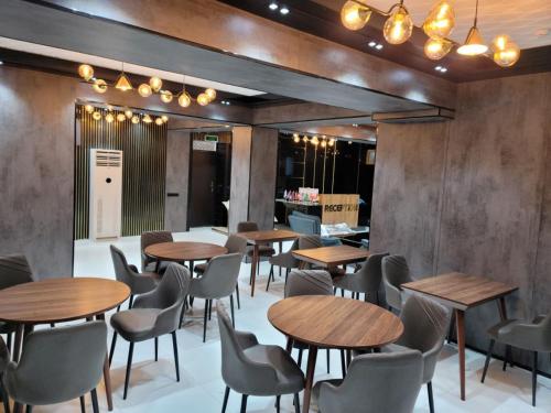 ein Restaurant mit Holztischen, Stühlen und Lampen in der Unterkunft Art Hotel Navoiy in Navoiy