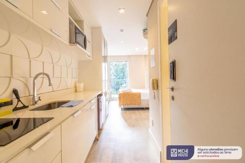 uma cozinha com balcões brancos, um lavatório e um corredor em MH 50201 - Charmoso Studio Expo CN AC/WF/GARAGEM em São Paulo