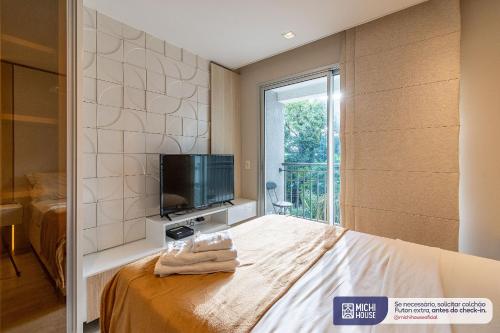 um quarto com uma cama, uma televisão e uma janela em MH 50201 - Charmoso Studio Expo CN AC/WF/GARAGEM em São Paulo