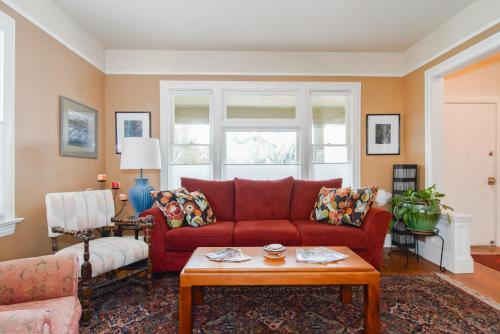 a living room with a red couch and a table at Big beautiful house off Alberta—2 bdms sunny patio in Portland