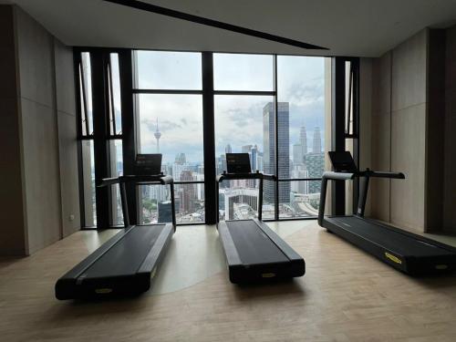 a gym with two treadmills in front of a large window at Axon Suites Kualalumpur in Kuala Lumpur