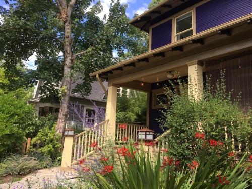 a house with a porch with flowers in the yard at Big beautiful house off Alberta—2 bdms sunny patio in Portland