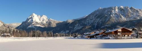 a ski lodge with snow covered mountains in the background at Landhaus Tröber in Grän