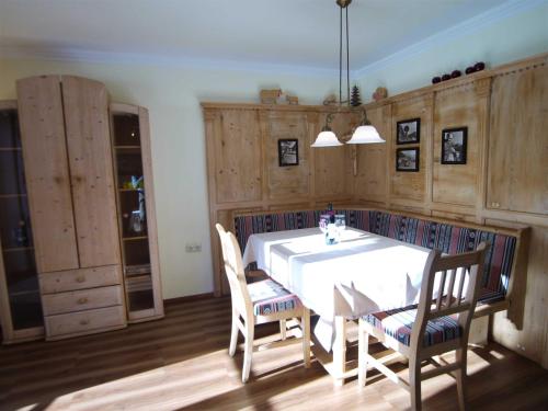 a dining room with a white table and chairs at Landhaus Tröber in Grän