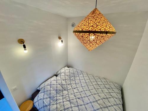 une chambre avec un lit et un lustre dans l'établissement Appart cozy rénové proche gares, balcon & parking, à La Madeleine