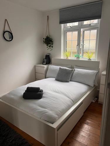 een wit bed in een slaapkamer met een raam bij Edgware Road Apartment in Londen
