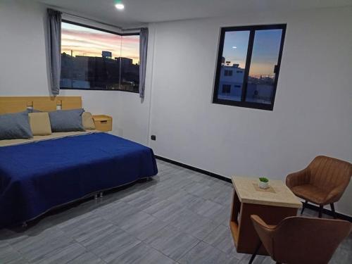 um quarto com uma cama azul e uma janela em Máster Suite Departamento cerca de Isla San Marcos em Aguascalientes