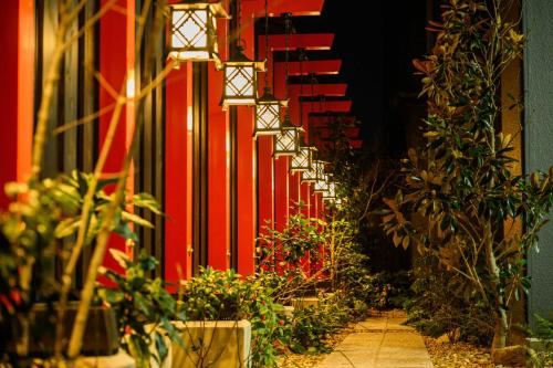 a hallway with plants and a red wall at Hotel Asyl Nara in Nara