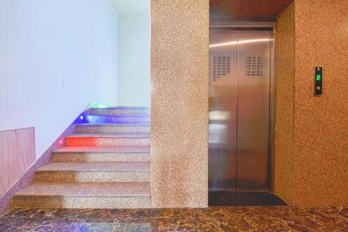 a staircase in a building with escalators and a elevator at FabHotel Prime The Royal Galaxy in Udaipur